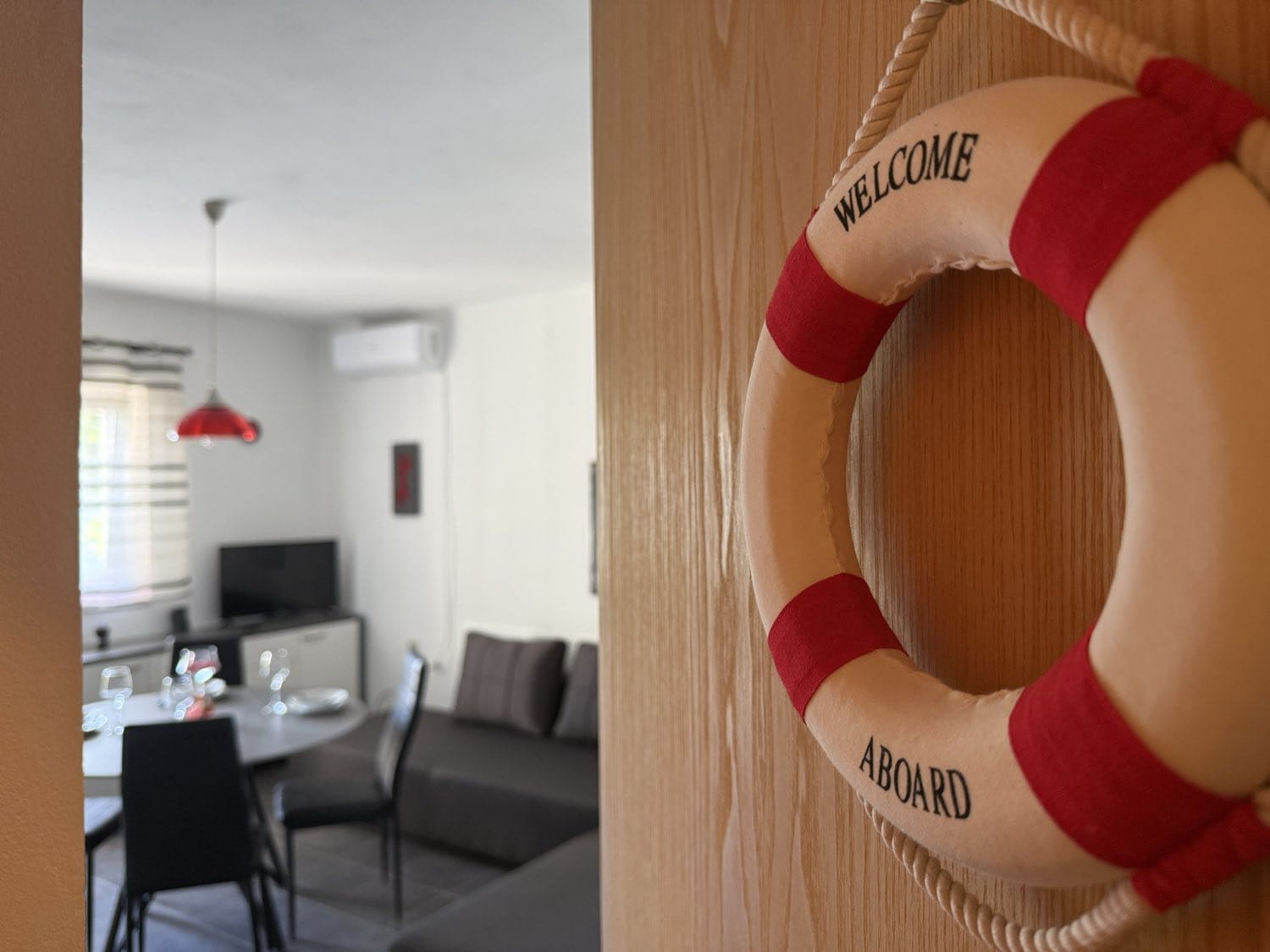 Coral Red apartment – entrance with “Welcome aboard” lifebuoy